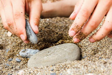 Figure game of TIC TAC toe painted on the pebbles