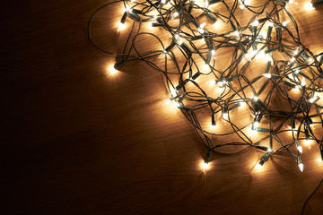 Fototapeta na wymiar Traditional Christmas Tree lights lying on a wooden floor.