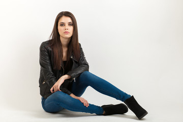 Portrait of sitting young calm beautiful brunette woman posing for model tests against white background