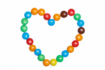 heart frame of colorful candy on a white background with space f