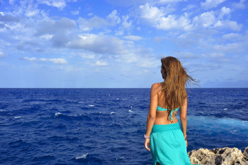 woman looking at sea horizon thoughtful from rock cliff  in relax concept