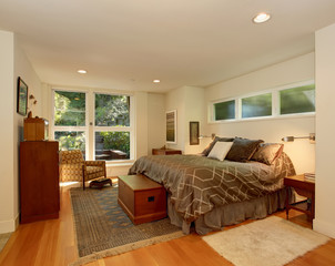 Luxury master bedroom with hardwood floor and brown bedding.