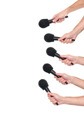 Several hands holding microphones