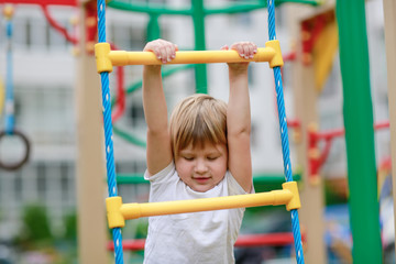 Fototapeta premium the girl climbs the stairs on the Playground