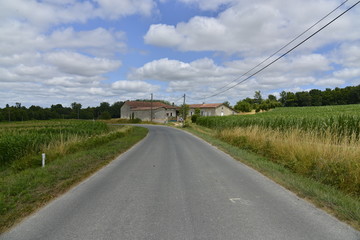 Fototapeta na wymiar Route de campagne passant près l'une des fermes typiques du Périgord Vert 