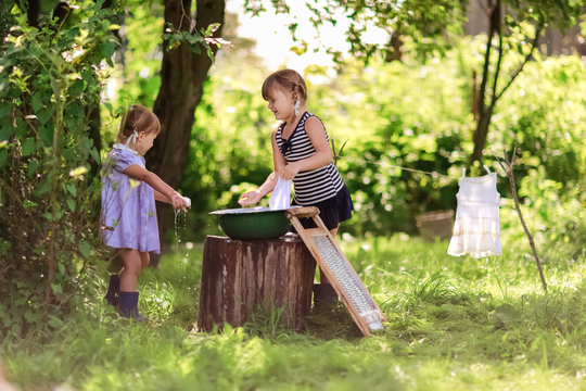 little helper girls sisters washes clothes using the washboard o