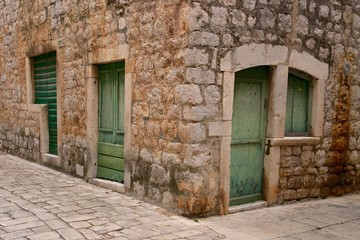 Fototapeta na wymiar Old stone house with green door in Stari Grad, Croatia