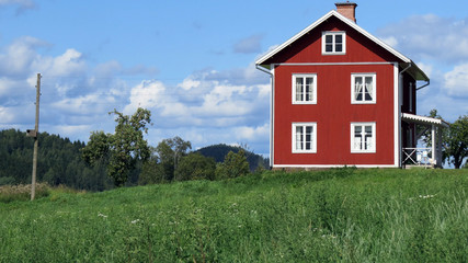 A lonely rural home with a telephony line passing by. The house is of a traditional Swedish country...