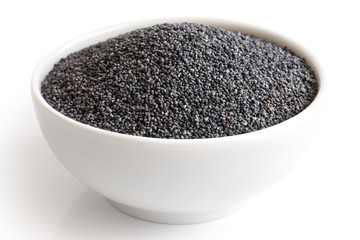 Ceramic bowl of poppy seeds isolated on white in perspective.