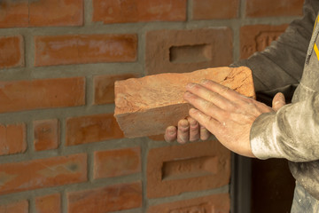 Men's hands are kept carved brick on brick wall background, man'