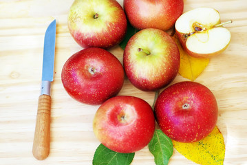Red organic apples on the wooden table and knife