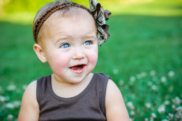 Cute little girl sitting on the grass