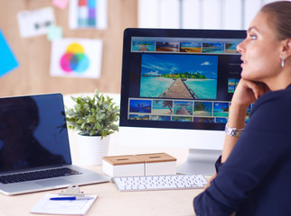 Young woman working in office, sitting at desk