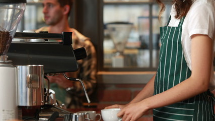 Smiling barista serving a client - Powered by Adobe
