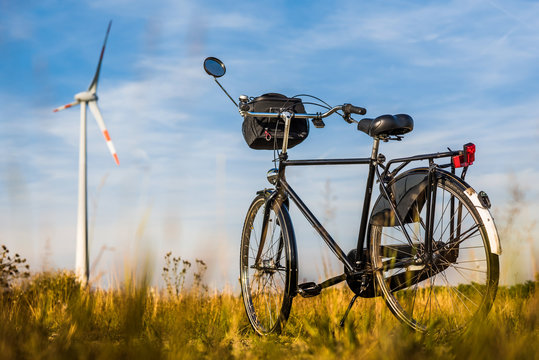 Fototapeta Fahrrad auf einer Wiese mit Windkraftanlage im Hintergrund