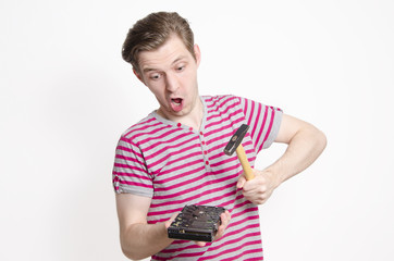 Funny, young man wants to destroy his hard disk by hitting it with a hammer