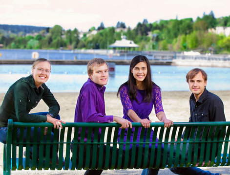 Four young multiethnic friends together at beach