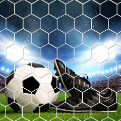 Soccer ball and shoes in grass, soccer stadium with the bright lights.