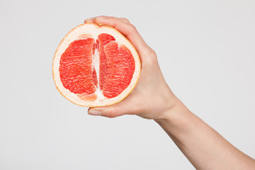 Female hand holding a  ripe cutting grapefruit