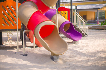 Red and violet pipe slides on modern kids playground