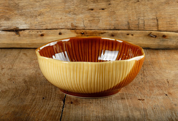 Empty brown bowl on the wooden background