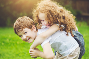 Happy children with piggyback riding. Girls laugh. Friendship co