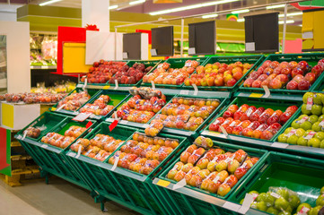 Bunch of different types of red apples in boxes in store