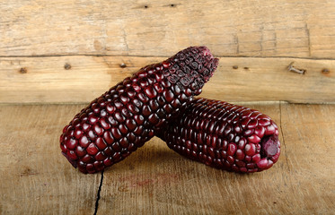 Red corn on the wooden background