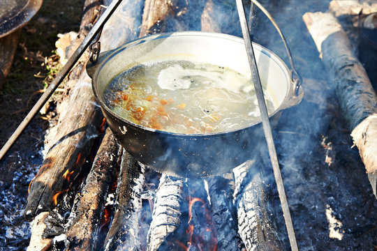 Cooking soup in the stowed bowler over campfire