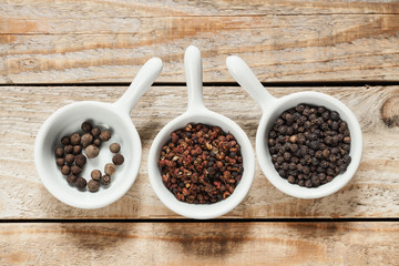 Bowls with dry pepper on wooden background