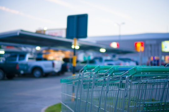 Row of shopping carts at entrance of supermarket near parking lo