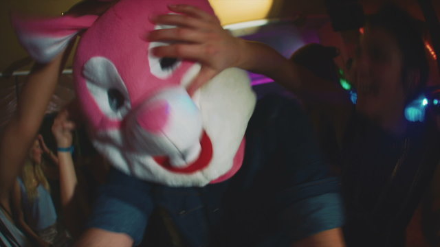 Guy with a bunny head with friends at party