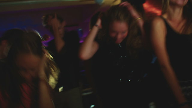 Friends dancing and singing together happily at a party
