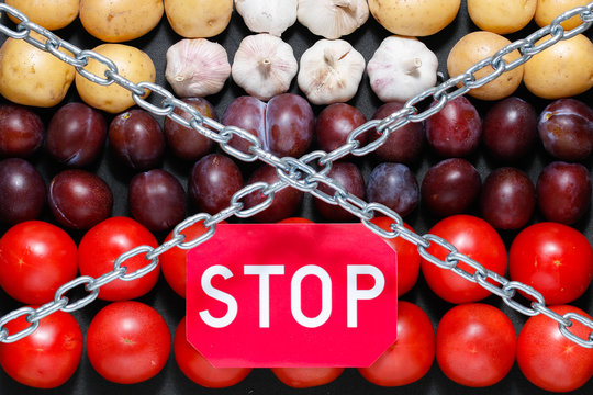 Chain And A 'stop' Sign On A Vegetables Background, In Context Of Sanctions And Extermination Of Food In Russia