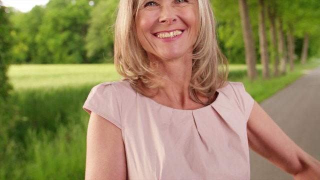 Mature woman in park holding a basket of vegetables