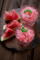 Delicious watermelon granitas over dark rustic wooden background