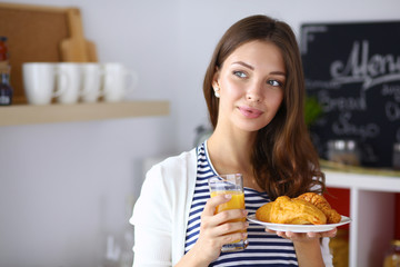 Young woman with glass of juice and cakes