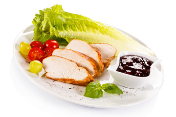 Roast chicken fillet and vegetables on white background 