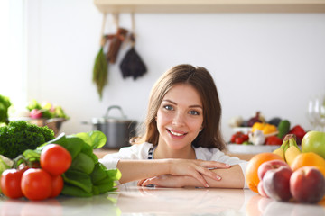 Young woman standing near desk in the kitchen