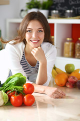 Young woman standing near desk in the kitchen