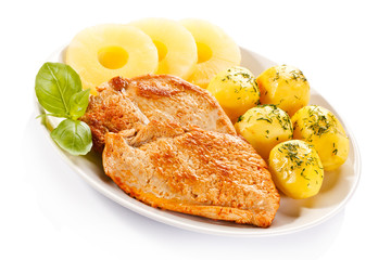 Fried chicken fillets, boiled potatoes and pineapples