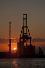 Port Miami at sunset with cargo crane silhouette vertical orientation