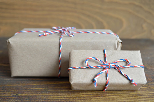 Brown paper parcel tied with string on wooden background 