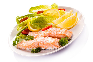 Roasted salmon and vegetables on white background