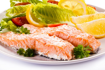Roasted salmon and vegetables on white background