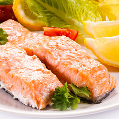 Roasted salmon and vegetables on white background