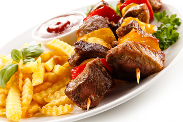 Grilled meat, French fries and vegetables 