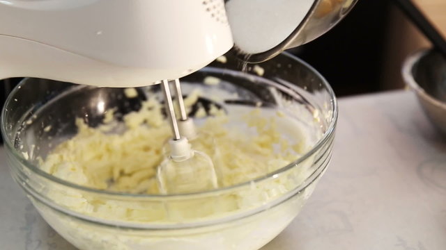 Blender stir and whip sugar and cream into cheese for cheesecake dessert