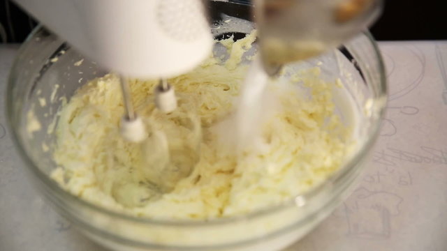 Blender stir and whip sugar and cream into cheese for cheesecake dessert