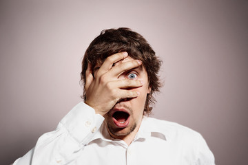 Closeup portrait of handsome young man looking shocked, surprise